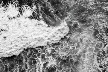 Fototapety  Coast of the tropical island - waves top view. Black-white photo.