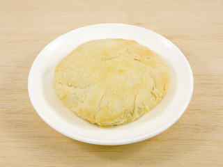 The Taiwanese sun cake (milk butter pastry) on the brown wooden plank.