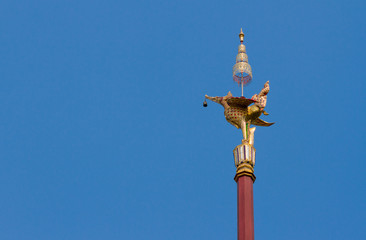 Fototapeta na wymiar Thai style golden bird lamp statue and blue sky