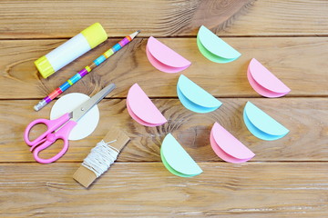 How to make a colored paper Christmas ball ornament. Step. Paper circles folded in half, scissors,...