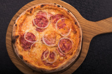hot italian pizza with salami on wooden board
