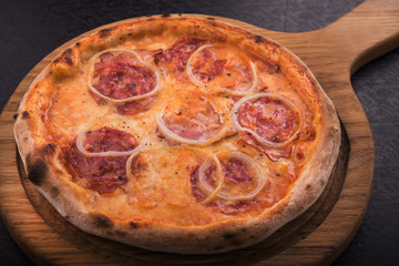 hot italian pizza with salami on wooden board