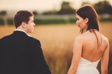 happy and young bride and groom look at each other