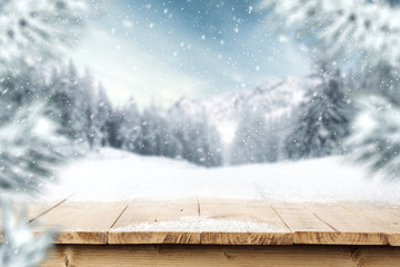 Table of wooden top and free space for your decoration of text or product. Landscape of mountains at winter time. Blurred branches of spruce and frost. 