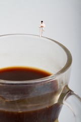 miniatura di medico sopra una tazzina di caffè