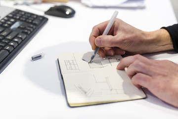 The Netherlands, Utrecht. Inside the factory of a Dutch design furniture brand. Designer sketching in his notebook.