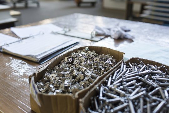 The Netherlands, Utrecht. Inside the factory of a Dutch design furniture brand.  A box of screws and other assembling utilities.