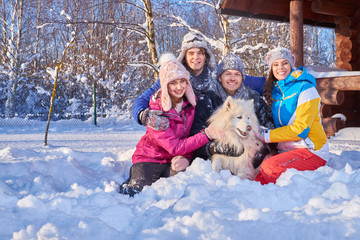 Cheerful friends with dog spend winter holidays together at mountain cottage