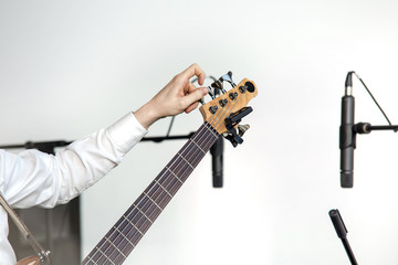 Bassist mit Stimmgerät stimmt seinen Bass