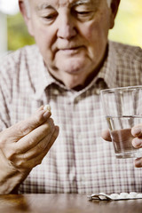 Senior nimm seine Meikamente ein, Tabletten, Medizin