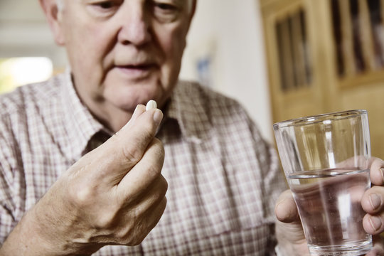 Senior nimm seine Meikamente ein, Tabletten, Medizin