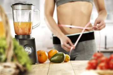 woman body in kitchen and blender on table 