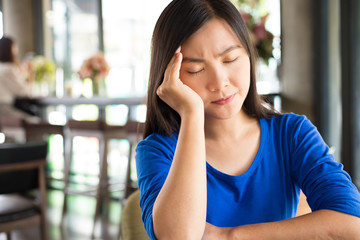 Woman has headache in the cafe