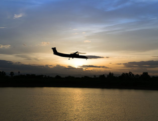 Airplane in the air and sunset in background