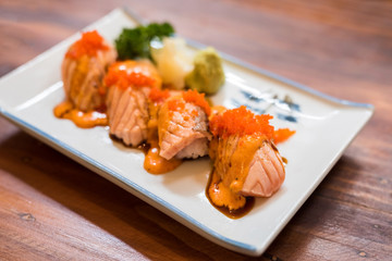 Grilled salmon sushi on white plate