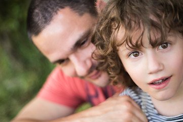 Fototapeta premium Young father with his son. Sunny summer nature.