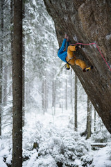 Rock climber on a challenging ascent. Extreme climbing. Unique winter sports. Scandinavian nature.