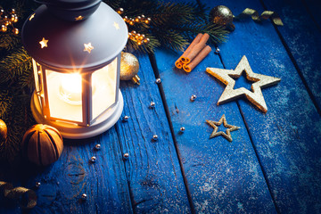 Christmas Lantern with decorations on blue wooden background