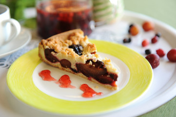 Berry tea, pie, glass teapot, sugar bowl and berries on the table with a green tablecloth