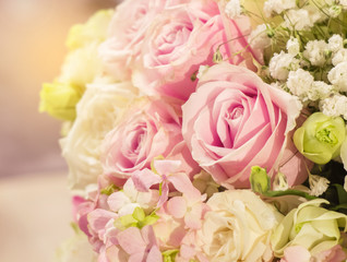 Beautiful Romantic Pink Rose Pattern in The Big Bouquet of Flowers Vase with Orange Sun Light Shade at The Corner for Interior Design, Selective Focus with Copy Space to input Text on Blur White Roses