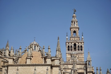 Fototapeta na wymiar Giralda, famous bell tower of the Seville Cathedral in Spanish city of Sevilla, built as a minaret and rebuilt as a tower of famous church as a symbol of Arab and Moorish architectural period in Spain