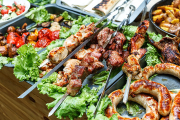 Grilling sausages and quail on the market showcase