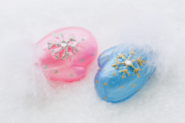 Blue and pink miniature mittens on a white background natural snow. Christmas, New Year.
