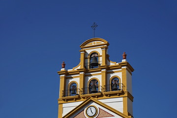 Top of the church in the town of La Linea de la Concepcion in southern Spain as a typical Spanish bell tower, symbol of Spanish religious architecture and design 