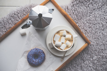 Warm cozy home. Tray and cup of coffee with marshmallows 