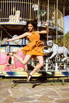 cool real teenage girl with candy near carousels at amusement pa