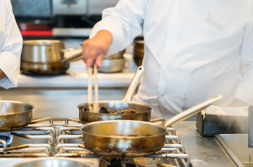 Chef in hotel or restaurant kitchen cooking
