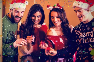 Composite image of smiling festive friends having shots