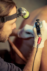 Artist making tattoo on male customer