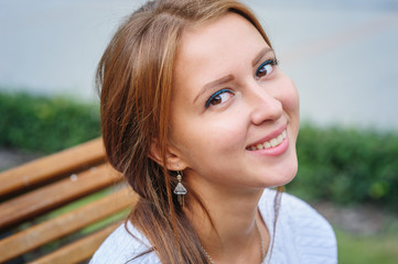 happy young woman sitting on a bench in the Park