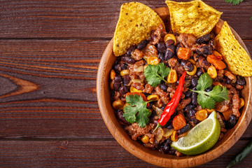 Chili con carne in bowl with tortilla chips.