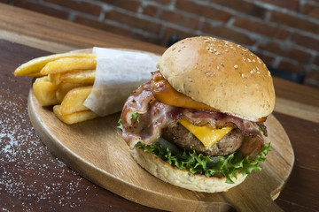 Burger and french fries on wooden table