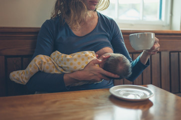 Woman breastfeeding baby in cafe © LoloStock