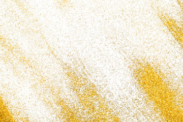 Golden glitter sand texture on white, abstract background.