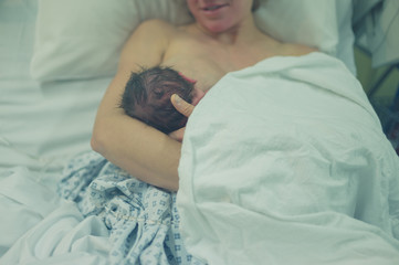 Mother with newborn baby in hospital bed