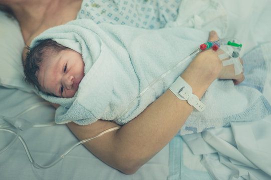 Mother with newborn baby in hospital bed
