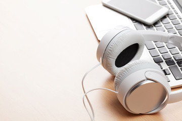 Obraz premium Headphones over laptop on wooden desk table