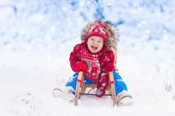 Kids play in snow. Winter sleigh ride for children