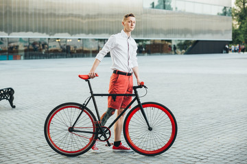 Hipster with red bycicle and tattoo on leg