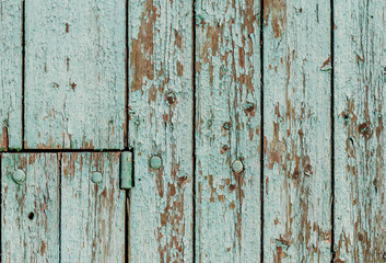Old wooden wall with green paint peeling off