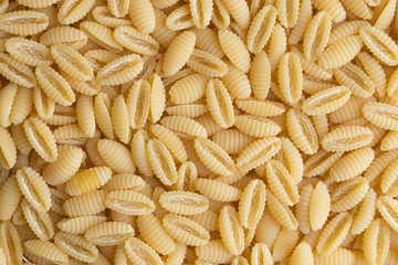 Pasta raw closeup background. Delicious dry uncooked ingredient for traditional Italian cuisine...