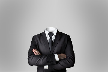 businessman without head crossed arms grey background - obrazy, fototapety, plakaty