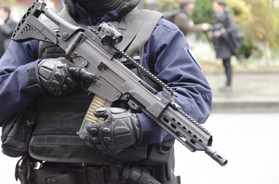 Policier en tenue d'intervention avec fusil d’assaut contre le terrorisme
