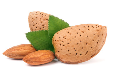 almonds in their skins and peeled with leaf isolated on white background