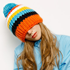 Stylish Brunette in a Hat with pompon and a blue jacket Snowboar