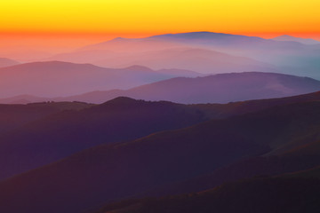 Naklejka na ściany i meble Silhouettes of the mountain hills at sunset